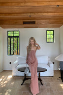 Woman in a Vogsion Strapless Twist Knot Satin Draped Maxi Dress standing in a room with white walls, wooden ceiling, and a white sofa.