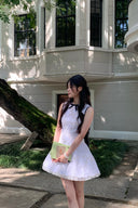 Woman in a Vogsion Shush Trong Renaissance Stiff Wool-Lace Coquette Dress standing in front of a building with large windows.