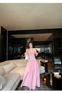 Woman in a pink dress standing in a modern living room.