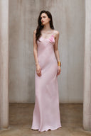 A minimalist 100% linen slip dress with a handcrafted rose detail on the bust and a low open back, designed for summer vacations, weddings, and elegant evening occasions — Last Sunset Rosette Linen Slip Dress available in soft blush pink and deep crimson red.