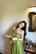 VOGSION Luna Lace Bandeau Gown in Pistachio green lace, featuring a strapless plunging neckline and braided detailing, modeled by a Vogsion custome