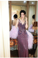 Woman in a Vogsion "Midnight Butterfly" Iridescent Sequin Backless Evening Gown with feathered sleeves standing in front of a mirror.