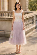     Vogsion Moonlit Lavender Petal ivory bodice lavender tulle midi dress with square neckline and ruffle straps in outdoor garden setting