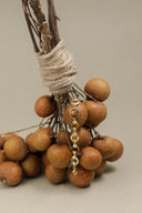 Decorative arrangement of brown spherical objects tied with twine on a beige background