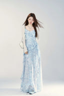 Woman wearing a light blue floral dress against a white background