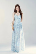 Woman wearing a light blue floral dress against a white background