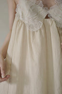 Vogsion Santorini Scalloped Lace Maxi Dress in cream, featuring delicate floral lace bust detailing and a fluid, floor-length silhouette.