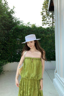 VOGSION Luna Lace Bandeau Gown in Pistachio green lace, featuring a strapless plunging neckline and braided detailing, modeled by a Vogsion custome