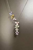 Necklace with colorful flower pendants on a plain background