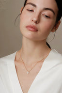     Vogsion Minuit Éclat dainty oval moissanite pendant necklace on gold-tone chain styled on natural customer-style model.
