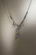 Necklace with floral pendant on a plain background