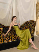 Chartreuse satin maxi dress, seated pose with flowing skirt