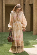 Woman in Vogsion Tiered Pleated Lace-Trimmed Printed Silk Maxi Skirt holding a handbag in an outdoor setting
