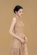 Woman wearing Vogsion Anabeila Ethereal Sculptural Lace Halter Midi Dress in Beige against a brown background