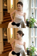 Woman in Vogsion Élodie Lace Corset Bow Satin Maxi Dress standing by a window with plants.