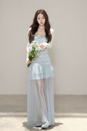 Vogsion customer wearing the Céleste light blue floral tiered tulle maxi dress with sheer skirt and romantic aesthetic for high-end summer fashion.
