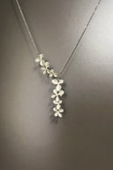 Silver necklace with floral pendant on a dark gray background
