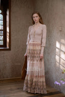 Woman in Vogsion Tiered Pleated Lace-Trimmed Printed Silk Maxi Skirt standing in a sunlit room.