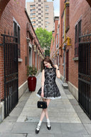 Woman in a Vogsion Shush Trong Renaissance Stiff Wool-Lace Coquette Dress standing in an urban alleyway.