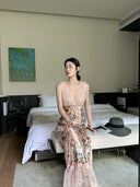 A woman wearing the Vogsion Bias Maxi Dress in Rose Garden Revolution, a pink and beige floral print dress with a ruffled mermaid hem and V-neckline, showcased by a real Vogsion customer