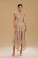 Woman wearing the Vogsion Anabeila Ethereal Sculptural Lace Halter Midi Dress in Beige against a beige background