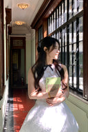 Woman in a Vogsion Shush Trong Renaissance Stiff Wool-Lace Coquette Dress holding a book in a sunlit hallway