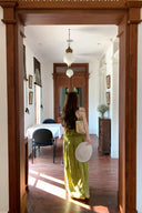 VOGSION Luna Lace Bandeau Gown in Pistachio green lace, featuring a strapless plunging neckline and braided detailing, modeled by a Vogsion custome