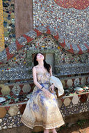 Vogsion Dawning Floral Corset Midi Dress featuring a blue and white boho floral pattern and tie straps, shown on a customer in a scenic vacation setting