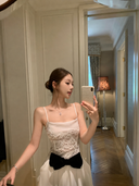 Woman taking a mirror selfie wearing Vogsion Élodie Lace Corset Bow Satin Maxi Dress.