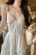 Close-up of premium camellia floral textured fabric on vogsion white dress, 3D floral chiffon material details.