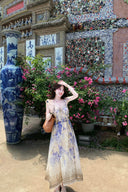 Vogsion Dawning Floral Corset Midi Dress featuring a blue and white boho floral pattern and tie straps, shown on a customer in a scenic vacation setting