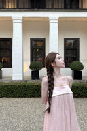 Woman in a Vogsion Odette Pearl-Trim Bubble Mini standing in front of a building with columns