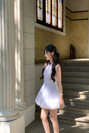Woman in a Vogsion Shush Trong Renaissance Stiff Wool-Lace Coquette Dress standing in a sunlit hallway with columns and a staircase.