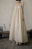Vogsion Santorini Scalloped Lace Maxi Dress in cream, featuring delicate floral lace bust detailing and a fluid, floor-length silhouette.