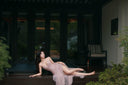 Vogsion blush corset gown reclining pose with flowy tulle skirt outdoor patio