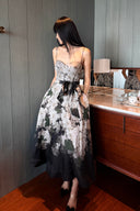 Vogsion Seraphina Floral Bustier Dress from the Kindred Spirit Spring 2026 collection, featuring a white and black botanical floral print, beaded straps, and a tie-waist, worn by a Vogsion customer in a historic European plaza