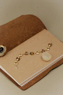 Gold bracelet with beads on a brown surface