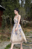 Vogsion Dawning Floral Corset Midi Dress featuring a blue and white boho floral pattern and tie straps, shown on a customer in a scenic vacation setting