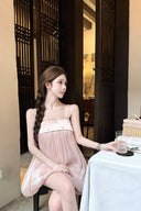 Woman in a Vogsion Odette Pearl-Trim Bubble Mini sitting at a table in a restaurant.
