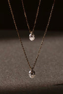    Close-up of Vogsion oval synthetic moissanite pendant necklace with gold-tone chain and delicate pavé-style connector.