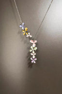 Necklace with pastel-colored flower pendants on a gray background