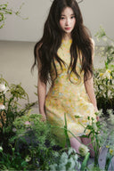 Vogsion Aurelia Soleil Floral Mini Dress worn by a normal customer in a botanical studio, high-end A-line silhouette, luxury yellow floral fashion, authentic customer photo.