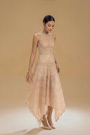 Woman wearing the Vogsion Anabeila Ethereal Sculptural Lace Halter Midi Dress in Beige  against a beige background