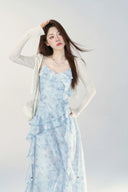 Woman wearing a light blue floral dress with a white background