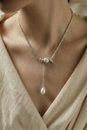 Vogsion Céleste Pearl Lariat Necklace with a pendant on a person wearing a light-colored garment.