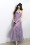 Woman wearing a purple floral dress against a white background