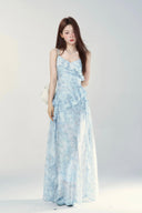 Woman wearing a light blue floral dress against a white background