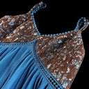 Close-up of a blue and patterned top with floral details on a black background