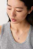 Woman wearing a Vogsion Darcy Reverie Oval Gemstone Pendant Necklace with a small pendant on a plain background