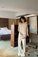 Side profile of the VOGSION Élan Quiet Luxury Linen Set highlighting the sculptural floral shoulder detail, soft linen draping, and relaxed silhouette inspired by modern quiet luxury and resort elegance.